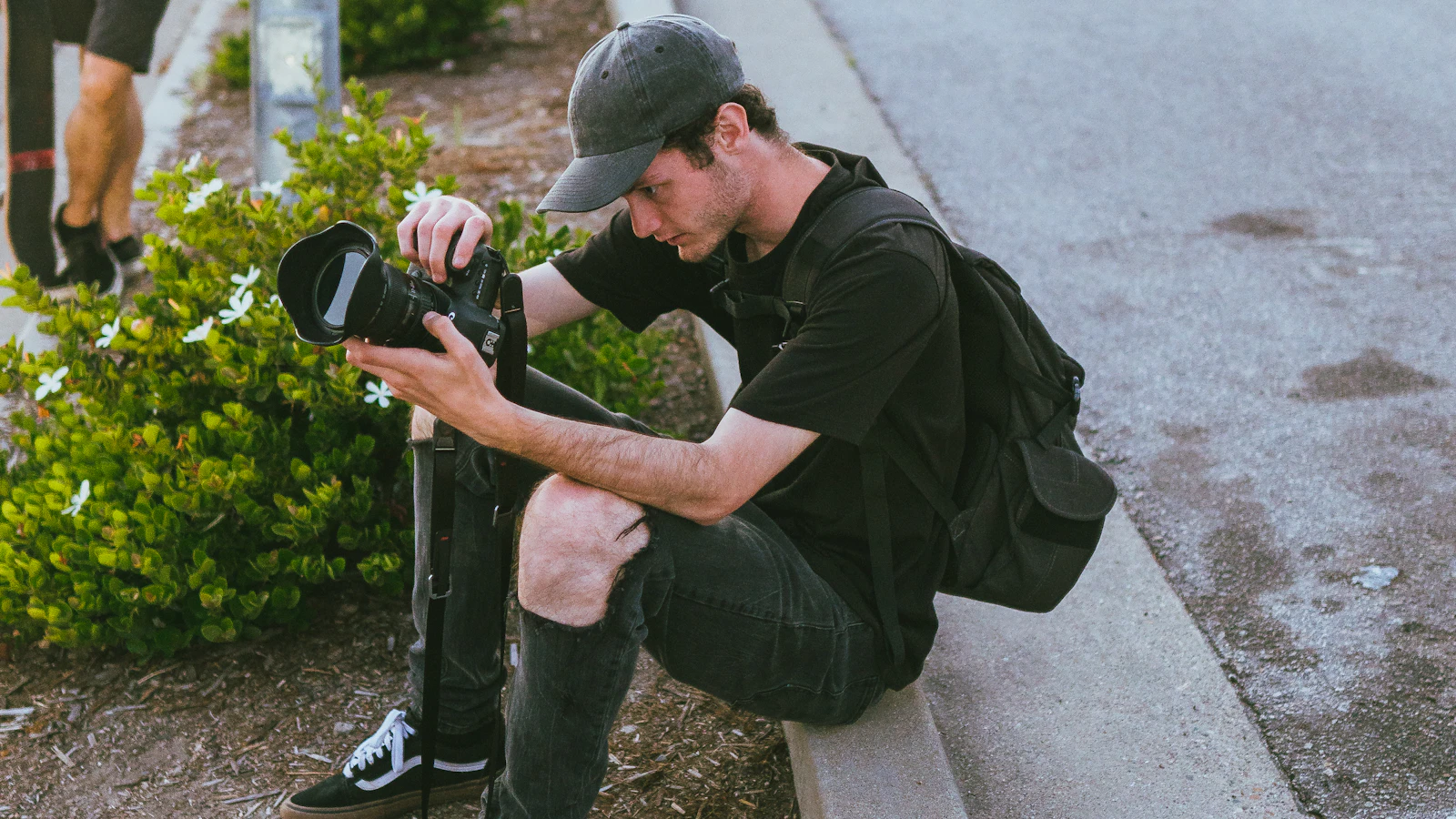 A creator photographing a car on the street with a DSLR camera